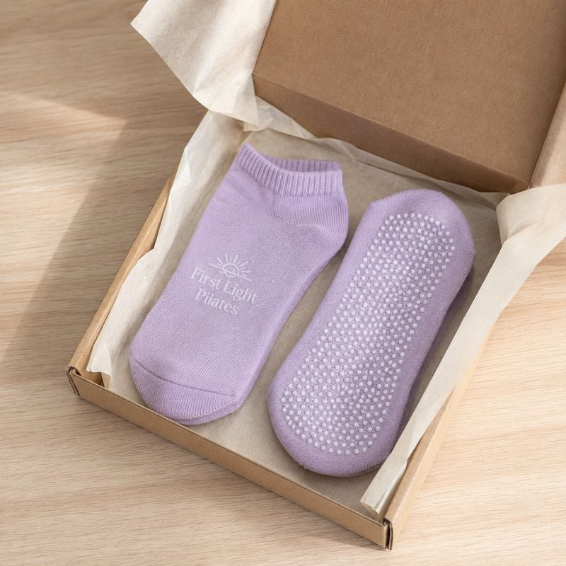 Personalized yoga grip socks packed in a kraft gift box with tissue paper